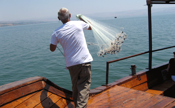 A fisherman casting his net out into the Sea of Galilee A fisherman casting his net out into the Sea of Galilee